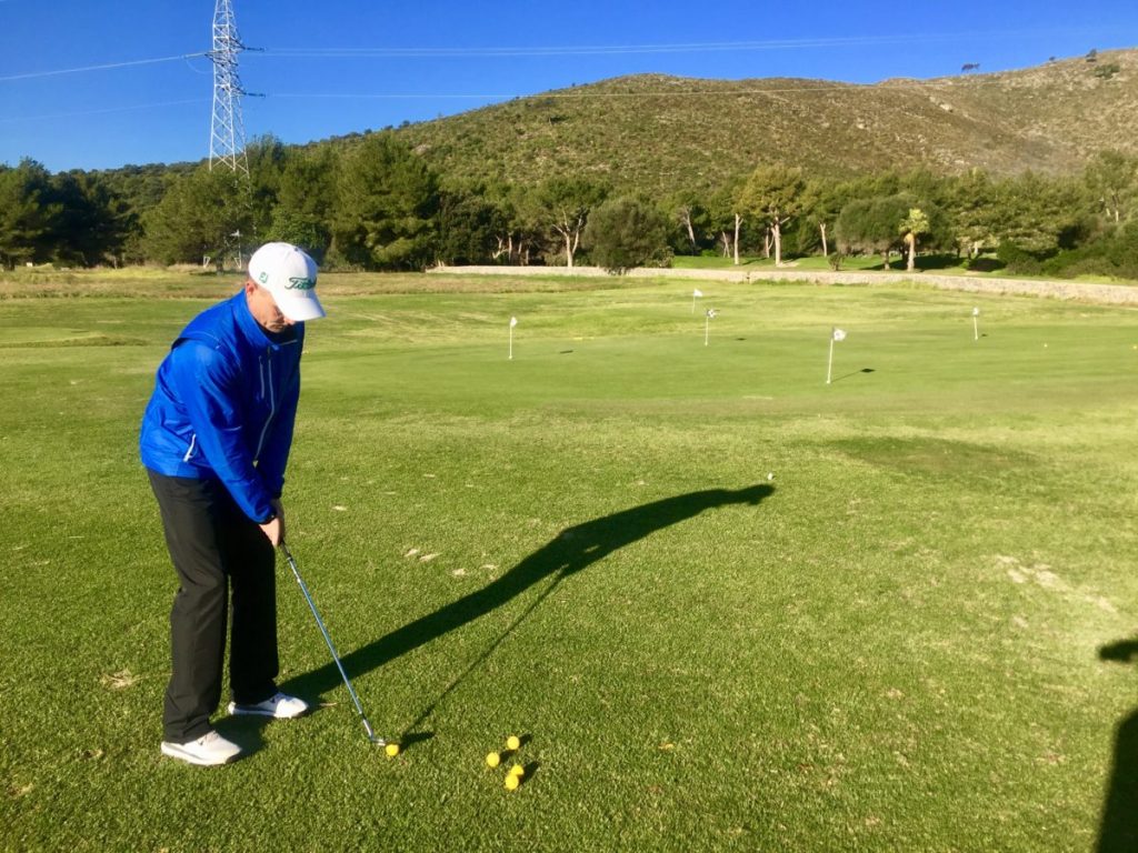Zwei Tees markieren den Bunker vor dem Grün, Fahne kurz gesteckt. Ball sicher aufs Grün und schnell stoppen.